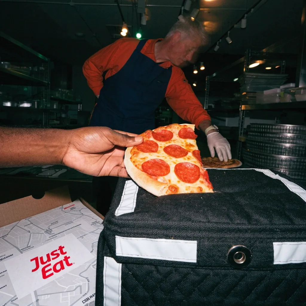 Table with fresh pizza inside a neighbourhood pizza store
